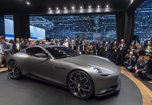 Visitors look at an electric car during the Geneva International Motor Show
