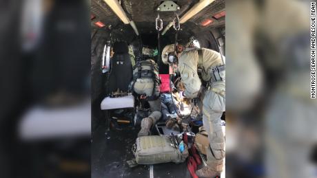 Rescuers treat a hiker who was being airlifted to a hospital. 