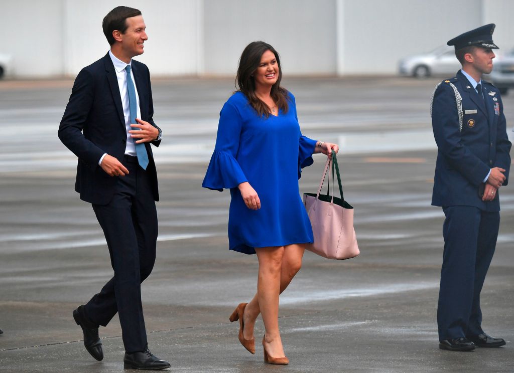 Jared Kushner and White House press secretary Sarah Sanders wait for the arrival of President Trump and first lady Melania Trump at Orlando International Airport on June 18, 2019.
