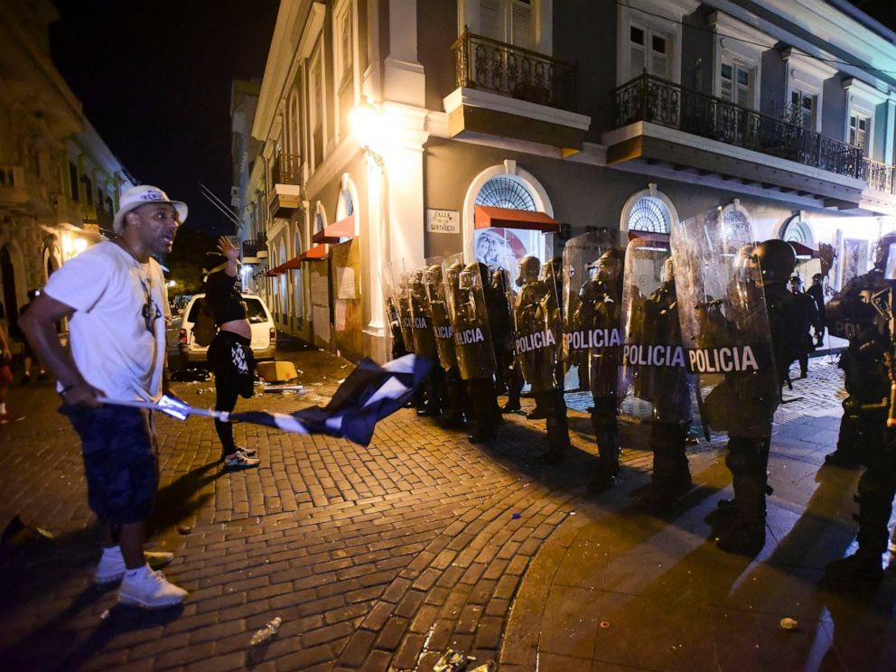 PHOTO: Demonstrators stand in front of riot control units during clashes in San Juan, Puerto Rico, Monday, July 22, 2019. Protesters are demanding Gov. Ricardo Rossello step down following the leak of an offensive, obscenity-laden online chat.