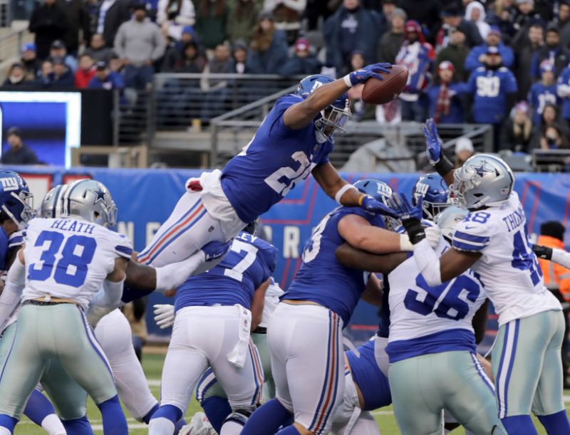 New York Giants' Saquon Barkley, top, scores a touchdown just before the ball is knocked from his hands during the second half of an NFL football game against the Dallas Cowboys, Sunday, Dec. 30, 2018, in East Rutherford, N.J. (AP Photo/Frank Franklin II)