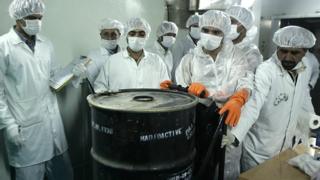 Iranian technicians remove a container of radioactive uranium, "yellow cake", sealed by the International Atomic Energy Agency, to be used at the Isfahan plant. Photo: August 2005