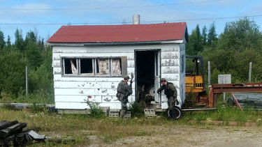 RCMP officers canvas homes and buildings in the Gillam, Manitoba area. The search has now moved to York Landing.