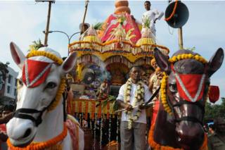 Indian devotees and members of the International Society for Krishna Consciousness (ISKCON) march alongside a chariot carrying a deity during the annual Rath Yatra Festival in Siliguri on June 24, 2009.