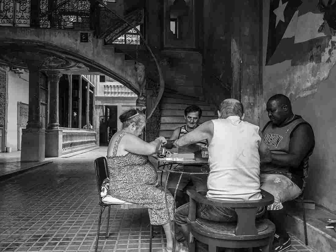 Four neighbors play dominoes at a residential building known as Solar de Aguilar in Havana, Cuba.