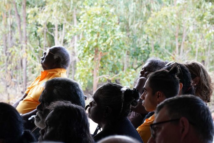 Michael Yunupingu sits in the crowd, with his grandfather Dr Galarrwuy Yunupingy out of focus in the background.