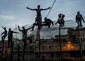Melilla, Spain, 2014: young Africans cling to the double fence that separates Africa from Europe.