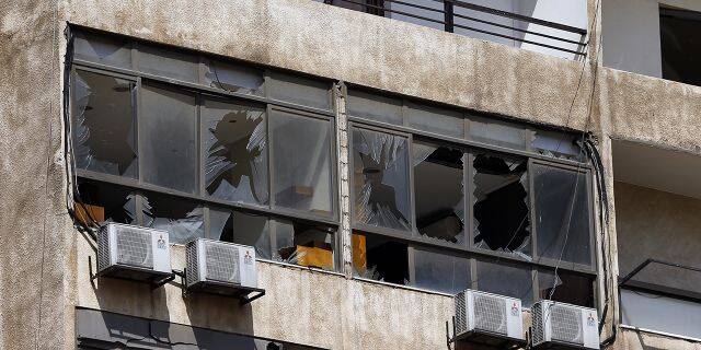 Broken windows are seen on the 11-floor building that houses the media office in a stronghold of the Lebanese Hezbollah group in a southern suburb of Beirut. (AP Photo/Bilal Hussein)