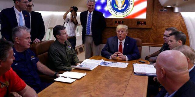 President Trump participates in a briefing with North Carolina Gov. Roy Cooper, left, and House Minority Leader Kevin McCarthy of Calif., standing center, about Hurricane Dorian at Marine Corps Air Station Cherry Point, Monday, aboard Air Force One. (AP Photo/Evan Vucci)
