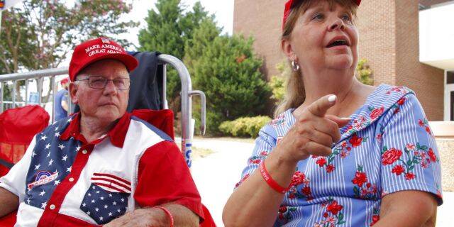 Philip Ezzell, left, and his wife, Diane Ezzell, from Marshville, N.C., talk about why they support President Trump as they wait in line to enter his latest rally on Monday. (AP Photo/Chris Seward)