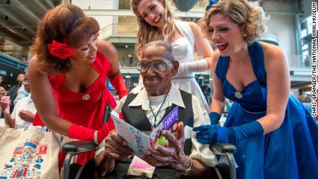 Singing group The Victory Belles give World War II veteran Lawrence Brooks a birthday card.