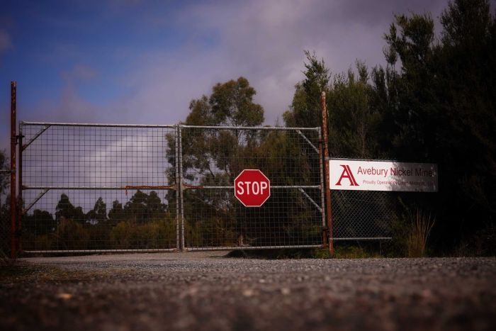 Locked gates with a stop sign at the entrance to the Avebury Nickel Mine.