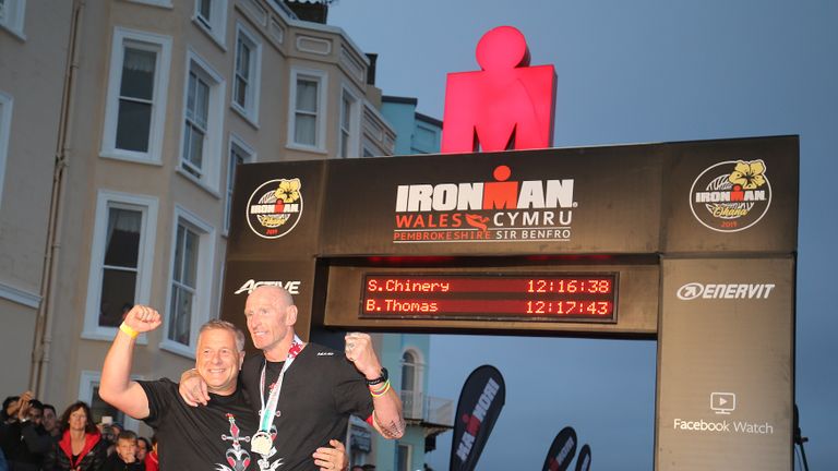 TENBY, WALES - SEPTEMBER 15:  Former Welsh rugby International captain Gareth Thomas (R) reacts after finishing Ironman Wales on September 15, 2019 in Tenby, Wales. (Photo by Nigel Roddis/Getty Images for IRONMAN)
