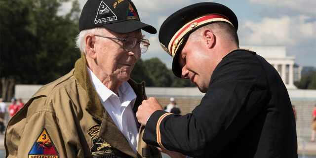 U.S. Army Major Peter Semanoff pins the Bronze Star Medal on WWII veteran Clarence Smoyer during the WWII Bronze Star Award Ceremony at the National WWII Memorial, Washington, D.C., Sept. 18, 2019. (DoD photo by U.S. Navy Petty Officer 2nd Class James K. Lee)