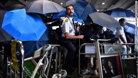 An airline crew member makes his way through a barrier set up by protesters at Hong Kong International Airport on September 1, 2019.