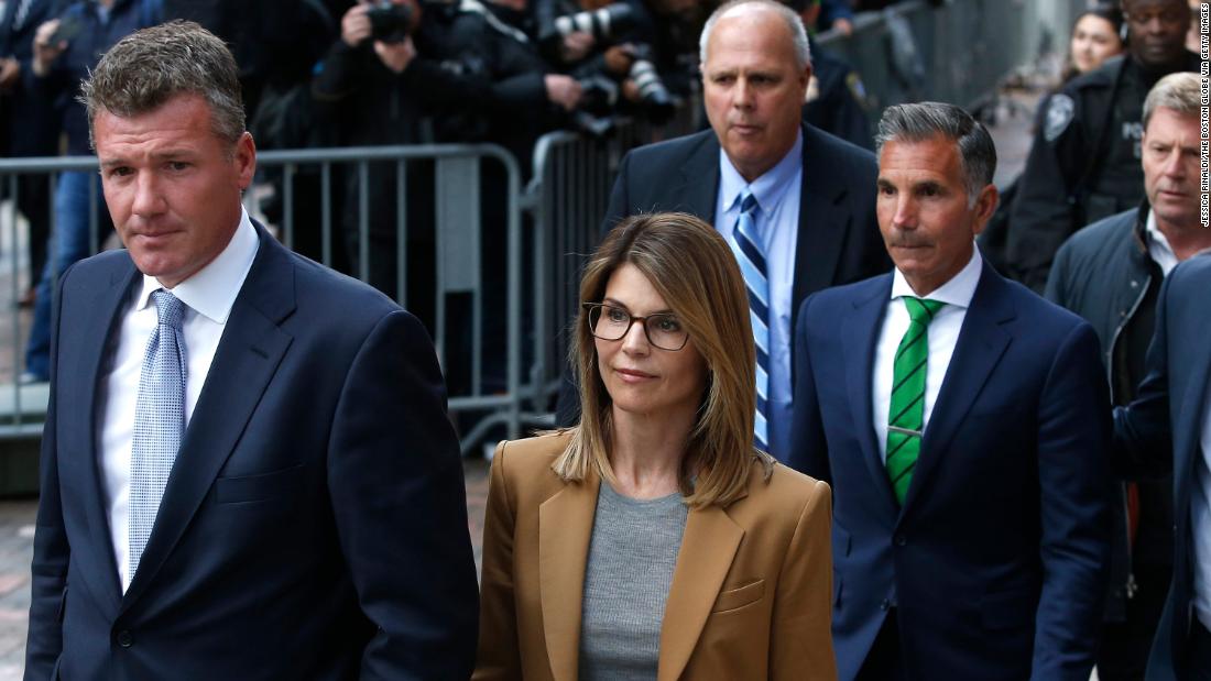 Actress Lori Loughlin, in tan at center, leaves as her husband Mossimo Giannulli, in green tie at right, follows behind her outside the John Joseph Moakley United States Courthouse in Boston on April 3, 2019.