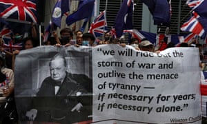 Anti-government protesters hold up banners and Union Jack flags outside the British consulate in Hong Kong.