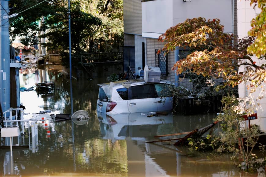 A car is seen partially submerged in a flooded residential of Kawasaki near the Tama River in Kawasaki on Sunday after Typhoon Hagibis hit the area. | REUTERS