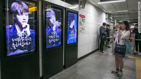A fan takes pictures of photos of BTS singer Jin which are displayed at Hongdae Subway Station on June 2, 2018 in Seoul, South Korea. Fans bought the advertising space to celebrate Jin&#39;s 5th anniversary of his debut with BTS.