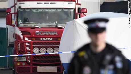 Police stand guard at the site where 39 bodies were discovered in the back of a lorry.