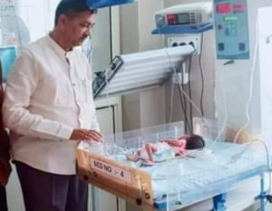 Local politician Rajesh Mishra with the newborn girl who was found after being buried alive.