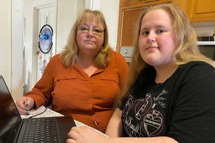 Deborah and Isabella Hollis sit in a kitchen with a laptop.