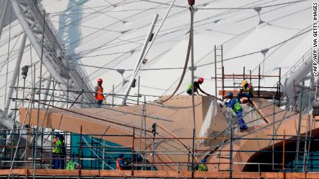 Workers are pictured on scaffolding at the Khalifa International Stadium in Doha.