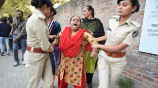 Gujarat Police officials detain a demonstrator during a protest against the Indian government's Citizenship Amendment Bill outside Indian Institute of Management (IIM) in Ahmedabad on Monday