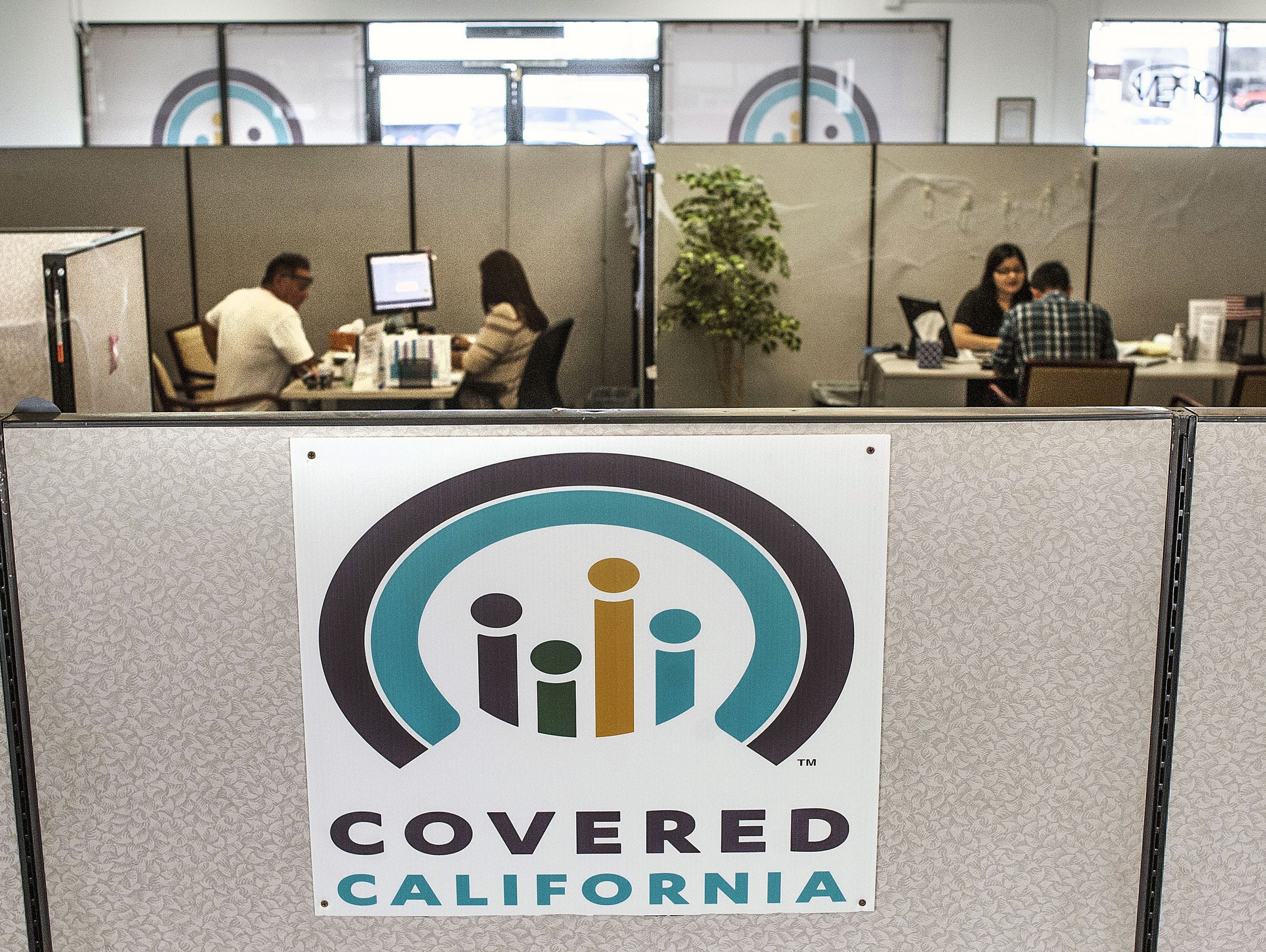 Insurance agents help sign people up for insurance through the Covered California exchange at their storefront in Huntington Beach on Nov. 1, 2016.
