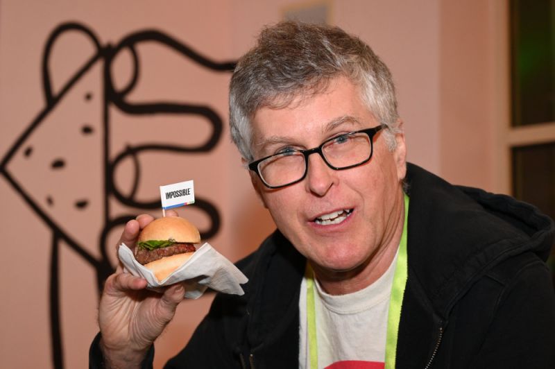 Impossible Foods CEO Pat Brown holds up an Impossible Burger 2.0, the new and improved version of the company's plant-based vegan burger that tastes like real beef, at a press event during CES 2019 in Las Vegas, Nevada on January 7, 2019. - The updated version can be cooked on a grill and has a better flavor and lowered cholesterol, fat and calories than the original. "Unlike the cow, we get better at making meat every single day," CEO of Impossible Foods CEO Pat Brown. (Photo by Robyn Beck / AFP) (Photo credit should read ROBYN BECK/AFP via Getty Images)