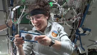 An astronaut holds a cookie on the International Space Station