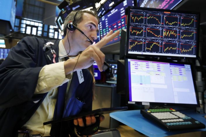 FILE - In this July 30, 2019 file photo, trader Gregory Rowe works on the floor of the New York Stock Exchange. An economic alarm bell is sounding in the U.S. and sending warnings of a potential recession. Yields on 2-year and 10-year Treasury notes inverted early Wednesday, Aug. 14, a market phenomenon that shows investors want more in return for short-term government bonds than they are for long-term bonds. (AP Photo/Richard Drew)