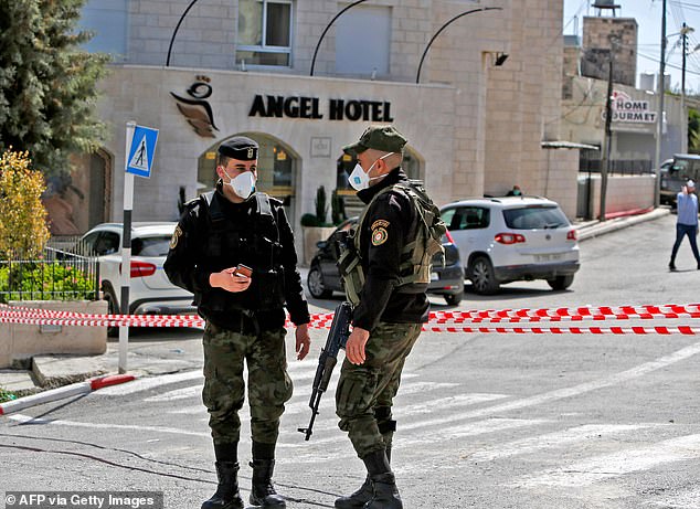 Palestinian security forces seal off the Angel Hotel in Beit Jala following suspected cases of coronavirus. Local churches, mosques and other institutions were closed Thursday