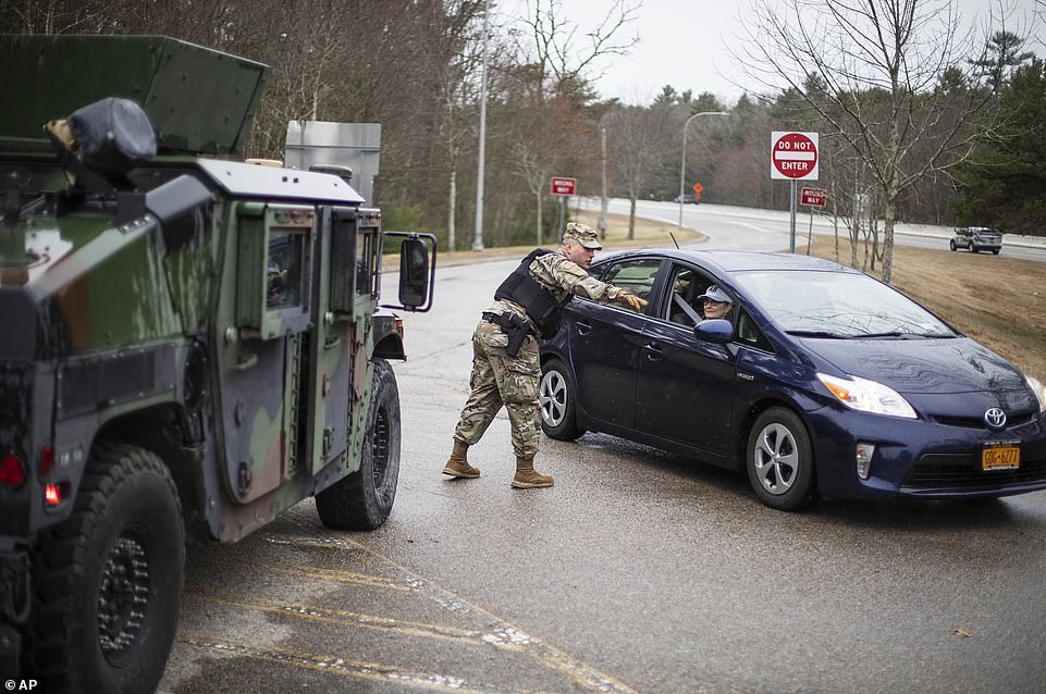A member of the Rhode Island National Guard Military Police directs a motorist with New York license plates at a checkpoint on I-95 over the border with Connecticut where New Yorkers must pull over and provide contact information and are told to self-quarantine for two weeks