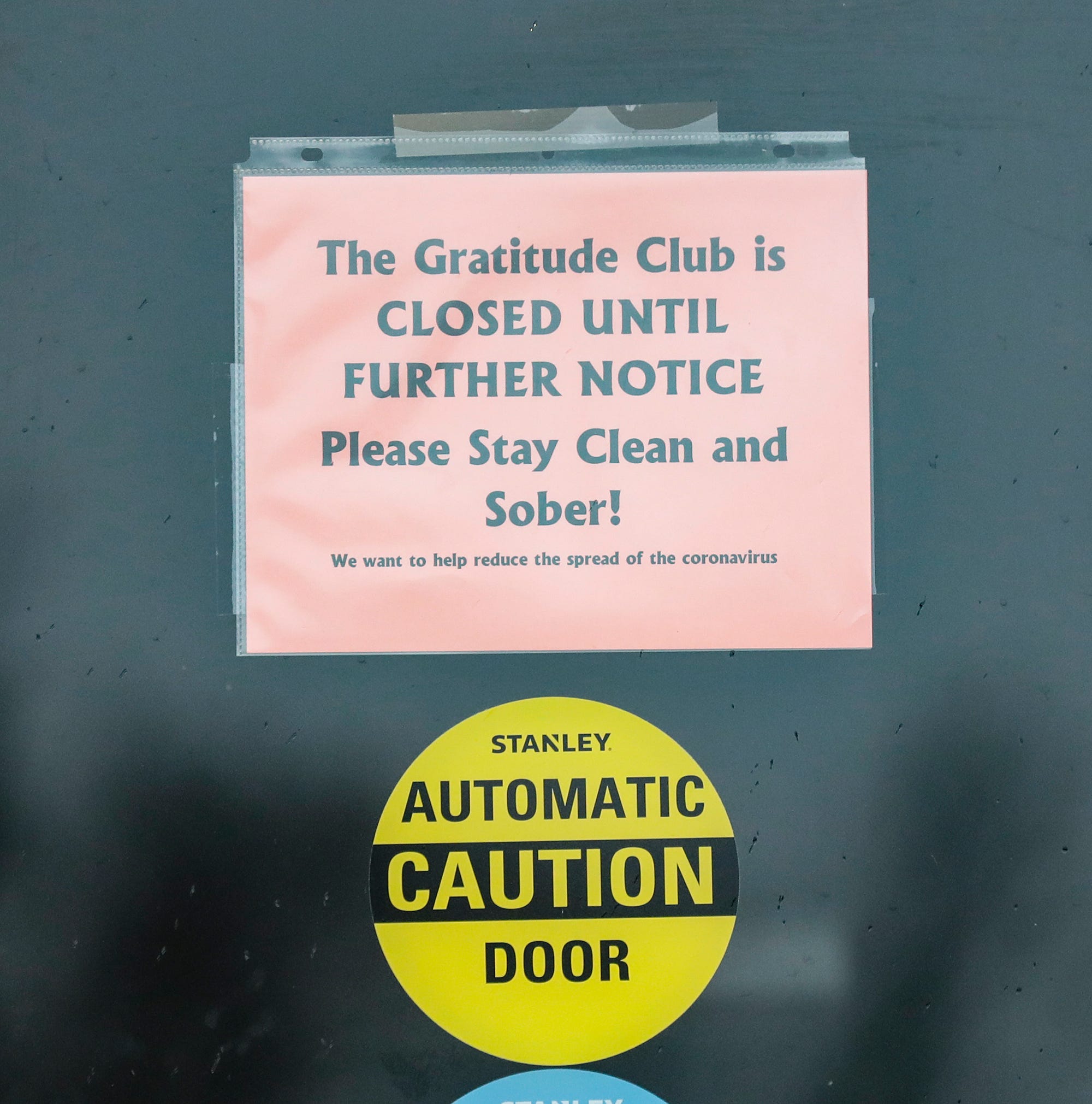 A sign on the Gratitude Club door Thursday, March 19, 2020 in Fond du Lac, Wis. announces it is closed.