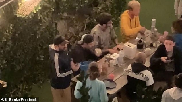 The video also cuts to a clip showing an aerial view of the hostel's patio area where a large group of backpackers are having a party