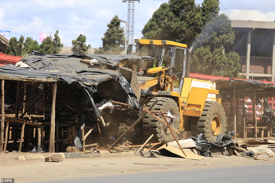 A front-end loader demolishes vending stalls in the township of Mbare, Zimbabwe, on Thursday amid the coronavirus crisis