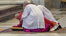 Pope Francis was helped to his feet as he celebrated Good Friday mass in St Peter
