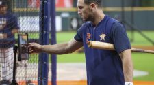 Houston Astros third baseman Alex Bregman looks at his swing on an iPad during batting practice