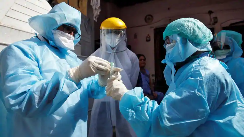 Doctors wearing protective gear seal a vial after taking a swab from a woman to test for coronavirus disease (COVID-19) at a residential area in Ahmedabad, India, April 9, 2020.