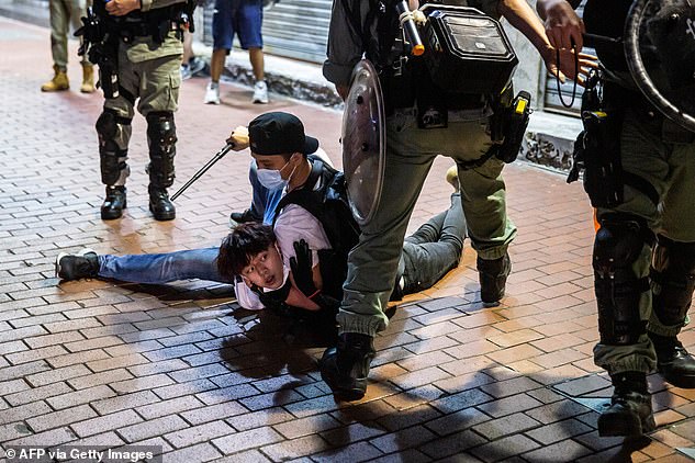 A pro-democracy demonstrator (centre) is held on the ground before getting arrested by undercover police during a protest calling for the city's independence in Mong Kok district of Hong Kong