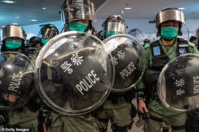 Riot police wearing protective masks stand guard during a demonstration in a shopping mall on May 10