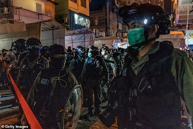 Riot police wearing protective masks secure an area during a crowd control operation in Mongkok district on May 10