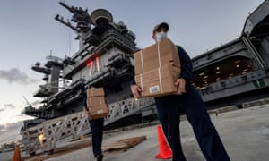 US Navy sailors assigned to the aircraft carrier USS Theodore Roosevelt carry meals in Guam.