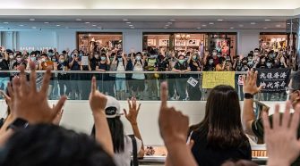 Anti-government protesters wearing protective masks sing songs and make gestures during a demonstration at a shopping mall today. Since the worst of the current coronavirus pandemic has passed, new anti-government protests have recently started to reappear in Hong Kong