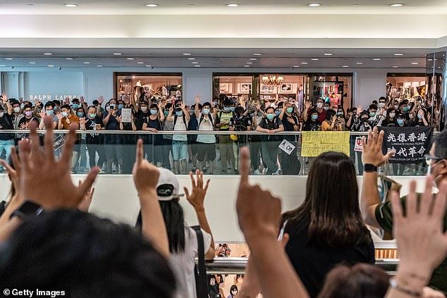 Anti-government protesters wearing protective masks sing songs and make gestures during a demonstration at a shopping mall today. Since the worst of the current coronavirus pandemic has passed, new anti-government protests have recently started to reappear in Hong Kong