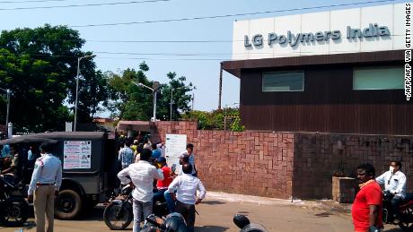 Policemen stand guard as people gather in front of a LG Polymers plant following a gas leak incident in Visakhapatnam on May 7.