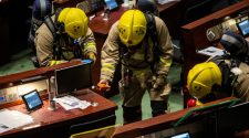 Members of the fire brigade perform tests in the main chamber of the Legislative Council after pan-democrat lawmakers hurled an…