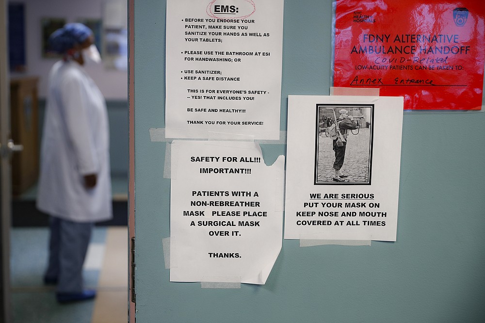 COVID-19 safety reminders hang on a wall in the emergency department intake area at NYC Health + Hospitals Metropolitan, Wednesday, May 27, 2020, in New York. At hospitals around the country, nurses, doctors and other health care workers are reckoning with the psychological toll of the virus fight, coupled with fears that the disease could flare anew later this year. (AP Photo/John Minchillo)