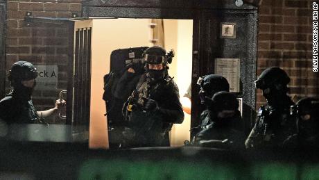 Armed police officers work at a block of flats in Reading after an incident at Forbury Gardens park in the town centre of Reading, England, Saturday.